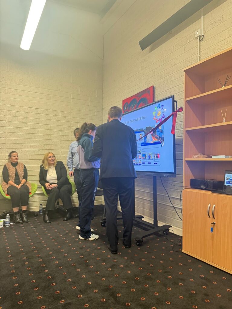 Minister James Browne and a Cumas New Ross member cutting the ribbon at the CommunitySafe website launch.